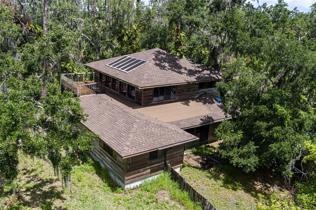 an aerial view of a house with a yard patio and deck
