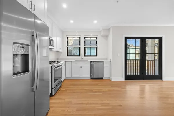 a view of a kitchen with stainless steel appliances wooden floor and a window