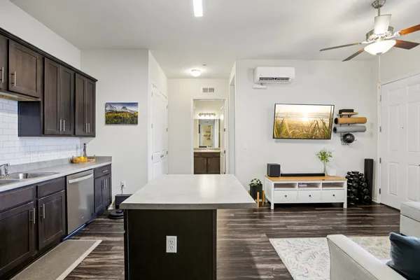 a living room with stainless steel appliances granite countertop a couch and cabinets