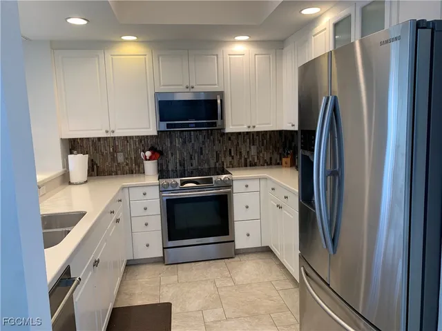 a kitchen with stainless steel appliances granite countertop a refrigerator and a sink