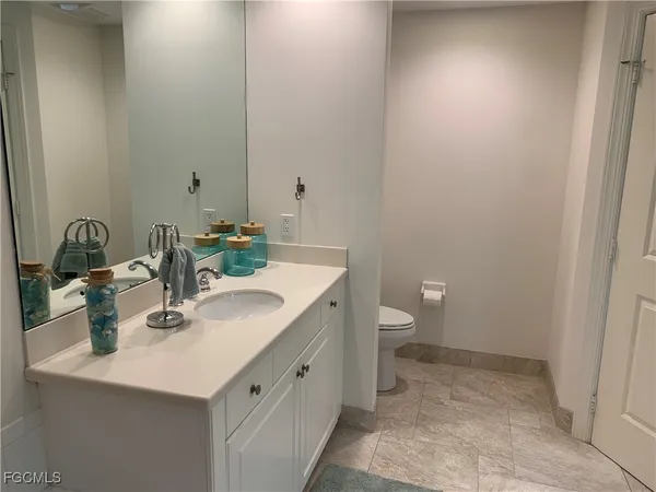 a bathroom with a sink a toilet and a mirror