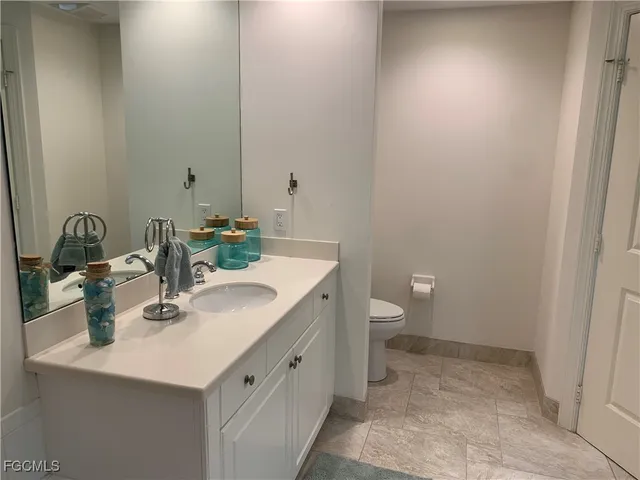 a bathroom with a sink a toilet and a mirror