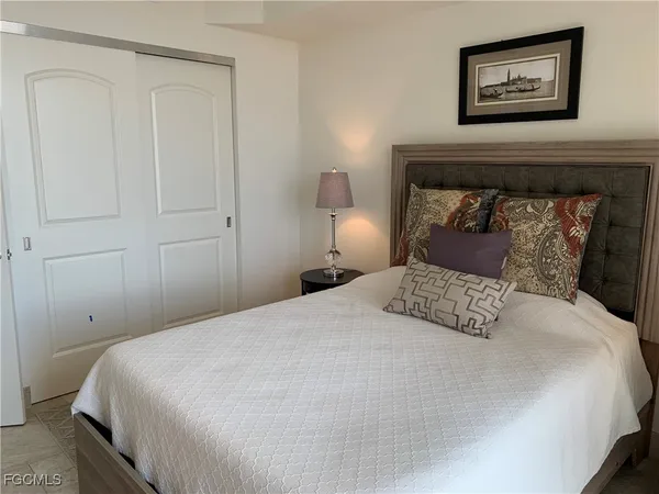 a bedroom with a bed and a painting on the wall