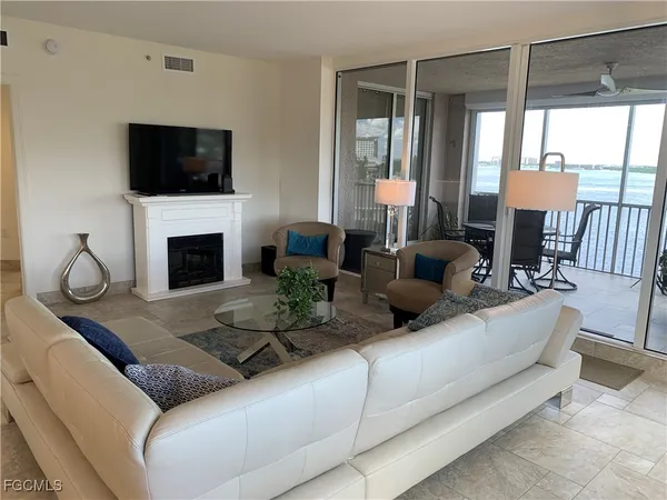 a living room with furniture a fireplace and a flat screen tv