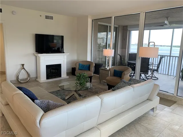 a living room with furniture a fireplace and a flat screen tv