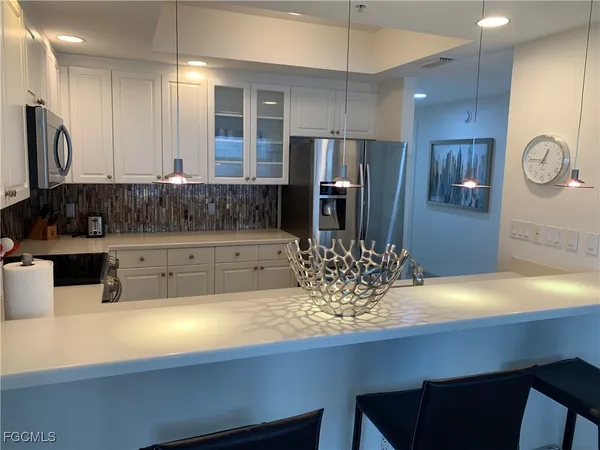 a kitchen with stainless steel appliances a sink refrigerator and microwave