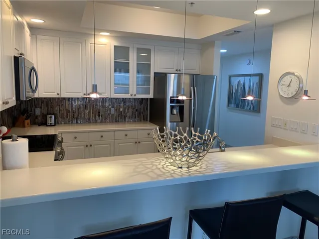 a kitchen with stainless steel appliances a sink refrigerator and microwave