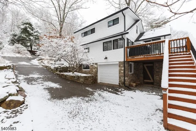 a view of a large white house with a snow on the road