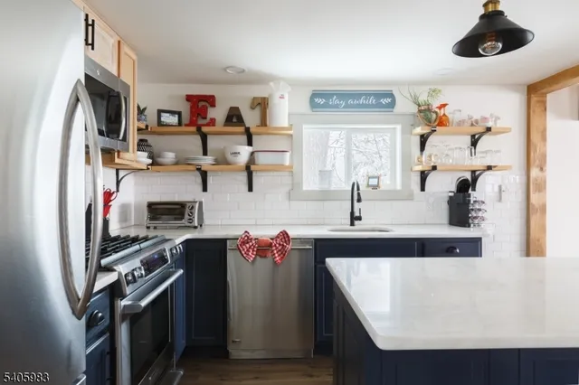 a view of a kitchen with a sink and refrigerator