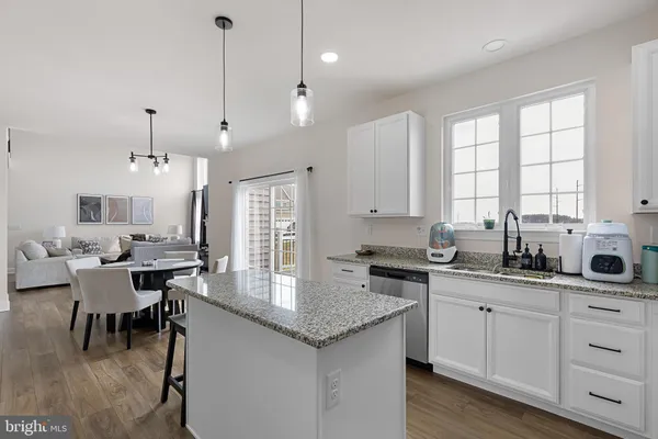 a kitchen with granite countertop a sink a center island a table and chairs