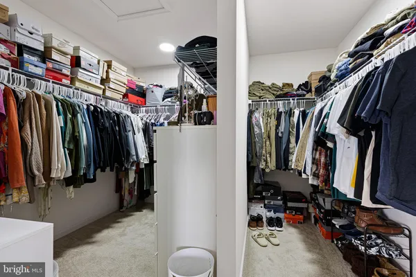 a view of walk in closet with clothes and shoes