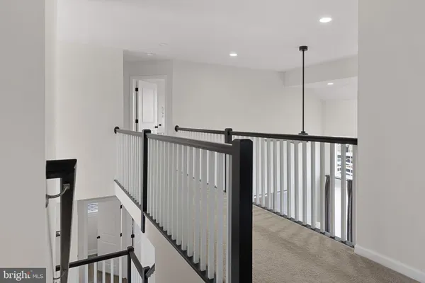 a view of a hallway with wooden floor and stairs