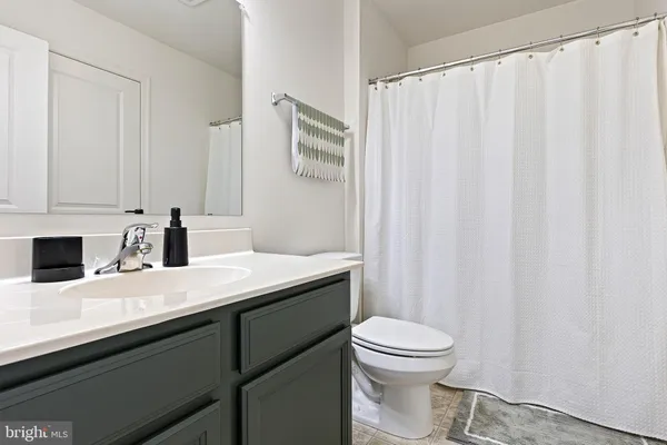 a bathroom with a granite countertop sink toilet and a mirror