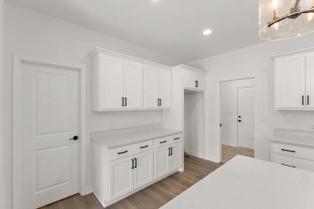 a kitchen with white cabinets and refrigerator