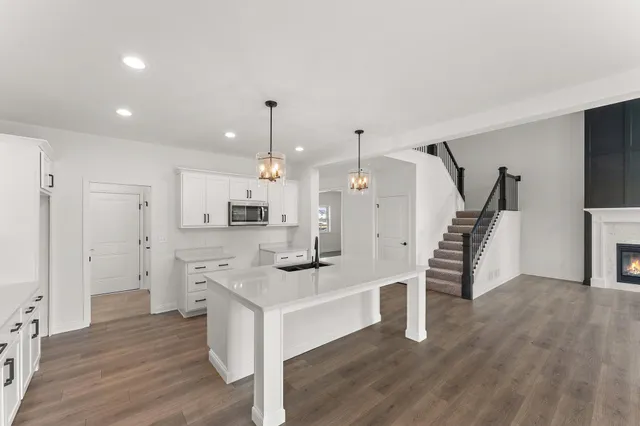a kitchen with stainless steel appliances sink refrigerator and wooden floor