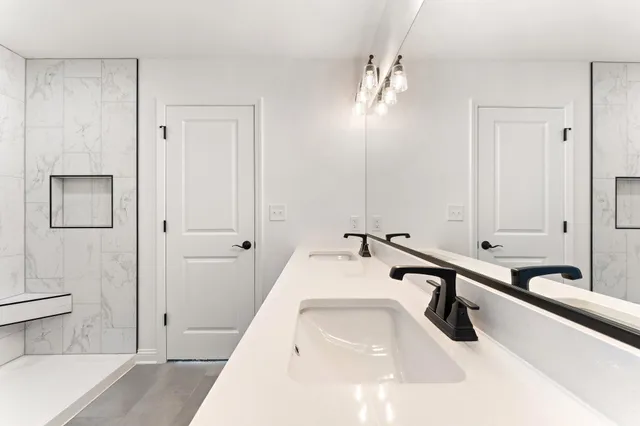 a bathroom with double vanity sinks and a mirror