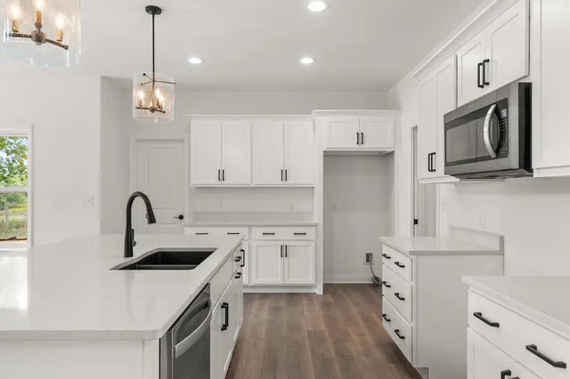 a kitchen with white cabinets stainless steel appliances and sink