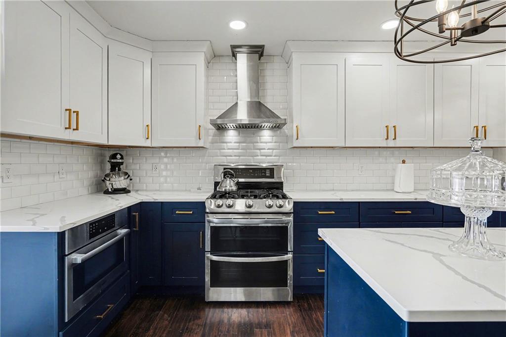 570 Morgan Court Hampton, GA 30228 - Photo 13 of 31 a kitchen with stainless steel appliances granite countertop a stove and white cabinets