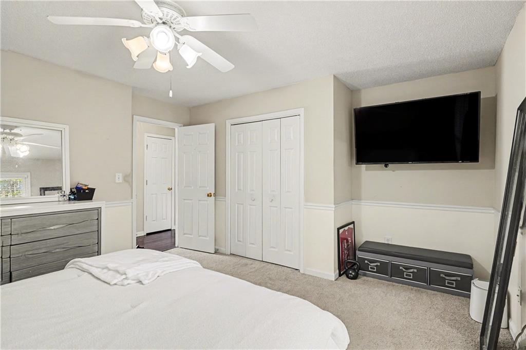 570 Morgan Court Hampton, GA 30228 - Photo 16 of 31 a bedroom with a bed and a flat tv screen on wall