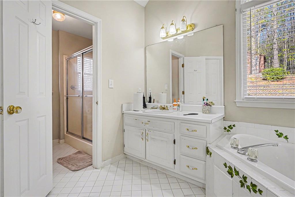 570 Morgan Court Hampton, GA 30228 - Photo 20 of 31 a bathroom with a tub a double vanity sink and a window