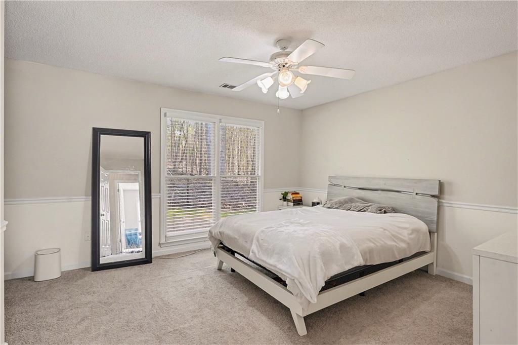 570 Morgan Court Hampton, GA 30228 - Photo 27 of 31 a bed sitting in a spacious bedroom next to a window