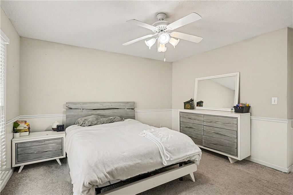 570 Morgan Court Hampton, GA 30228 - Photo 28 of 31 a bedroom with a bed and a chandelier