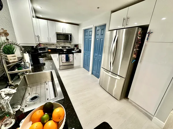 a kitchen with stainless steel appliances granite countertop a refrigerator stove and microwave