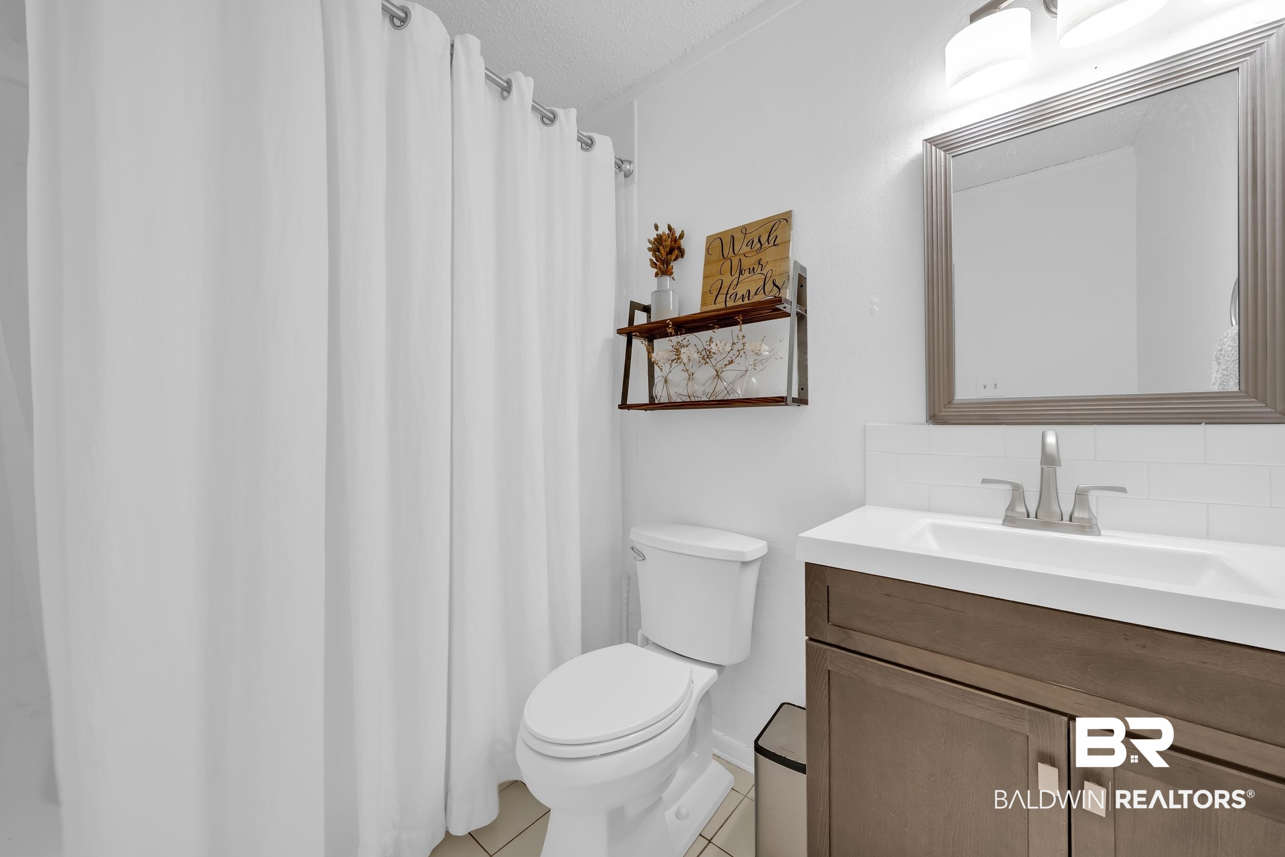 9660 Howells Ferry Road Semmes, AL 36575 - Photo 16 of 23 Bathroom with vanity, light tile patterned floors, and a shower with shower curtain