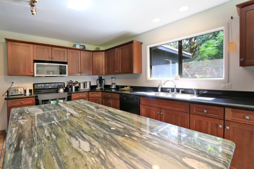 84 South Holokai Road Haiku, HI 96708 - Photo 9 of 17 a kitchen with granite countertop a stove a sink and a microwave