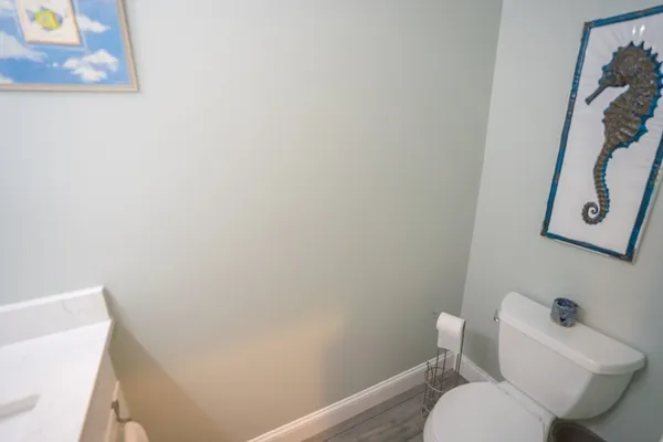 a white toilet sitting next to a white wall