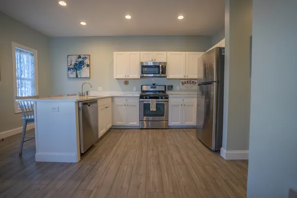 a kitchen with stainless steel appliances granite countertop a stove cabinets and wooden floor