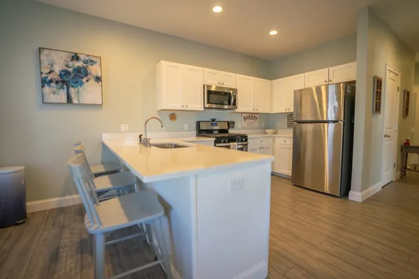 a kitchen with kitchen island a refrigerator stove and microwave