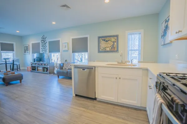 a kitchen with a sink stove and wooden floor