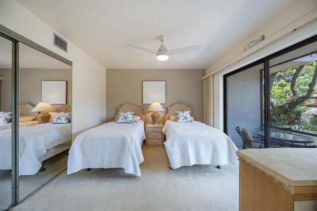 a bedroom with two beds and large windows