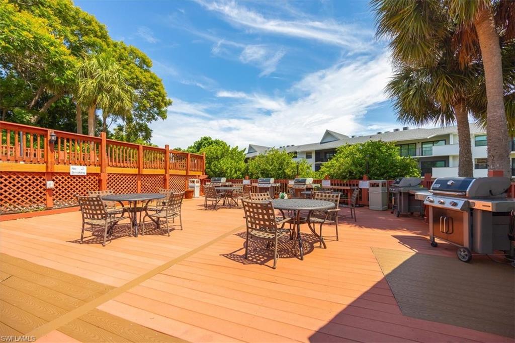 600 Neapolitan Way, Unit 115 Naples, FL 34103 - Photo 21 of 25 a outdoor space with lots of tables a garden view and chairs