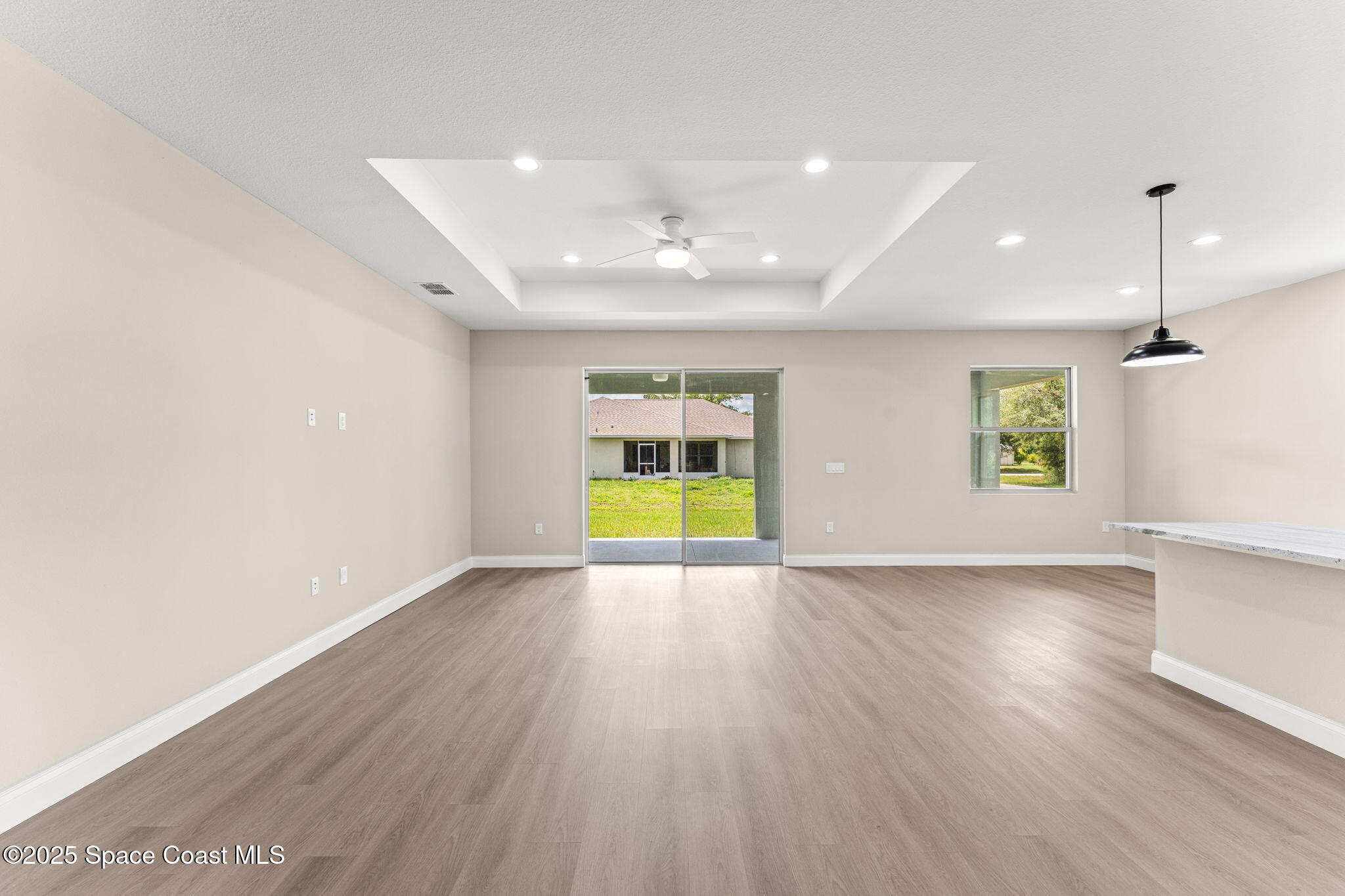 241 Sarah Road Southwest Palm Bay, FL 32908 - Photo 12 of 54 an empty room with wooden floor and windows