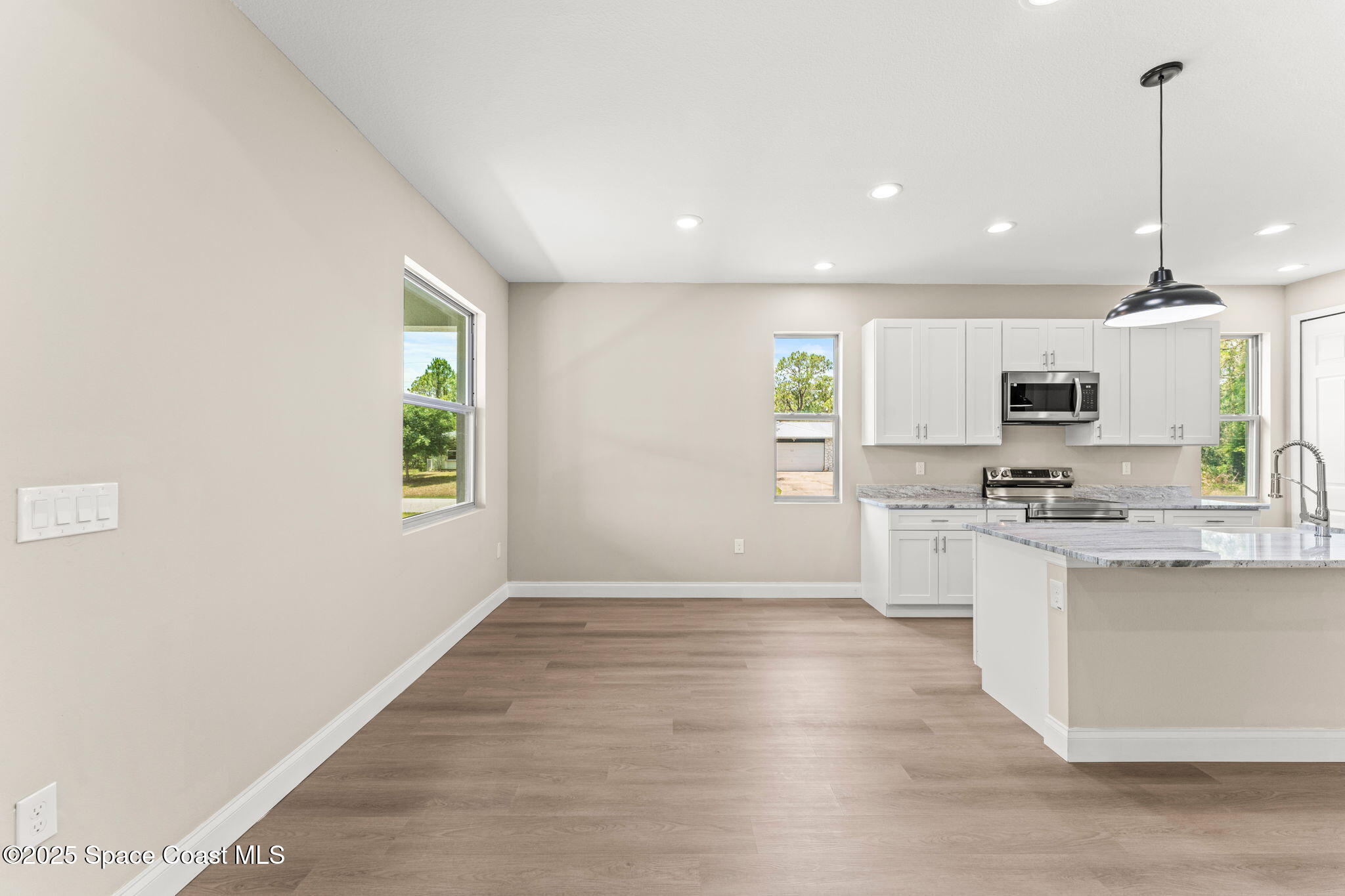 241 Sarah Road Southwest Palm Bay, FL 32908 - Photo 14 of 54 a kitchen with stainless steel appliances granite countertop a stove top oven a sink dishwasher and a refrigerator with wooden floor