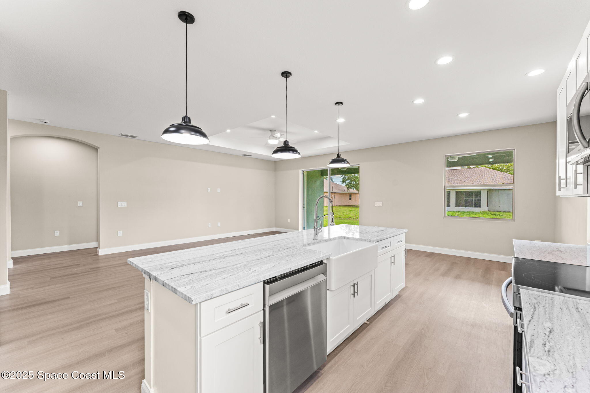 241 Sarah Road Southwest Palm Bay, FL 32908 - Photo 20 of 54 a kitchen with kitchen island a sink stainless steel appliances and a chandelier