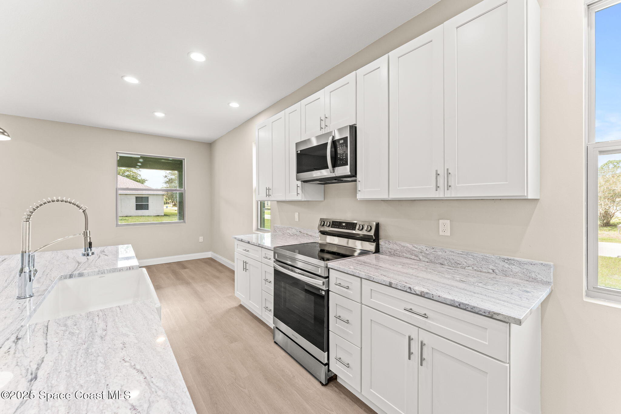 241 Sarah Road Southwest Palm Bay, FL 32908 - Photo 21 of 54 a kitchen with stainless steel appliances granite countertop a stove a sink and a microwave
