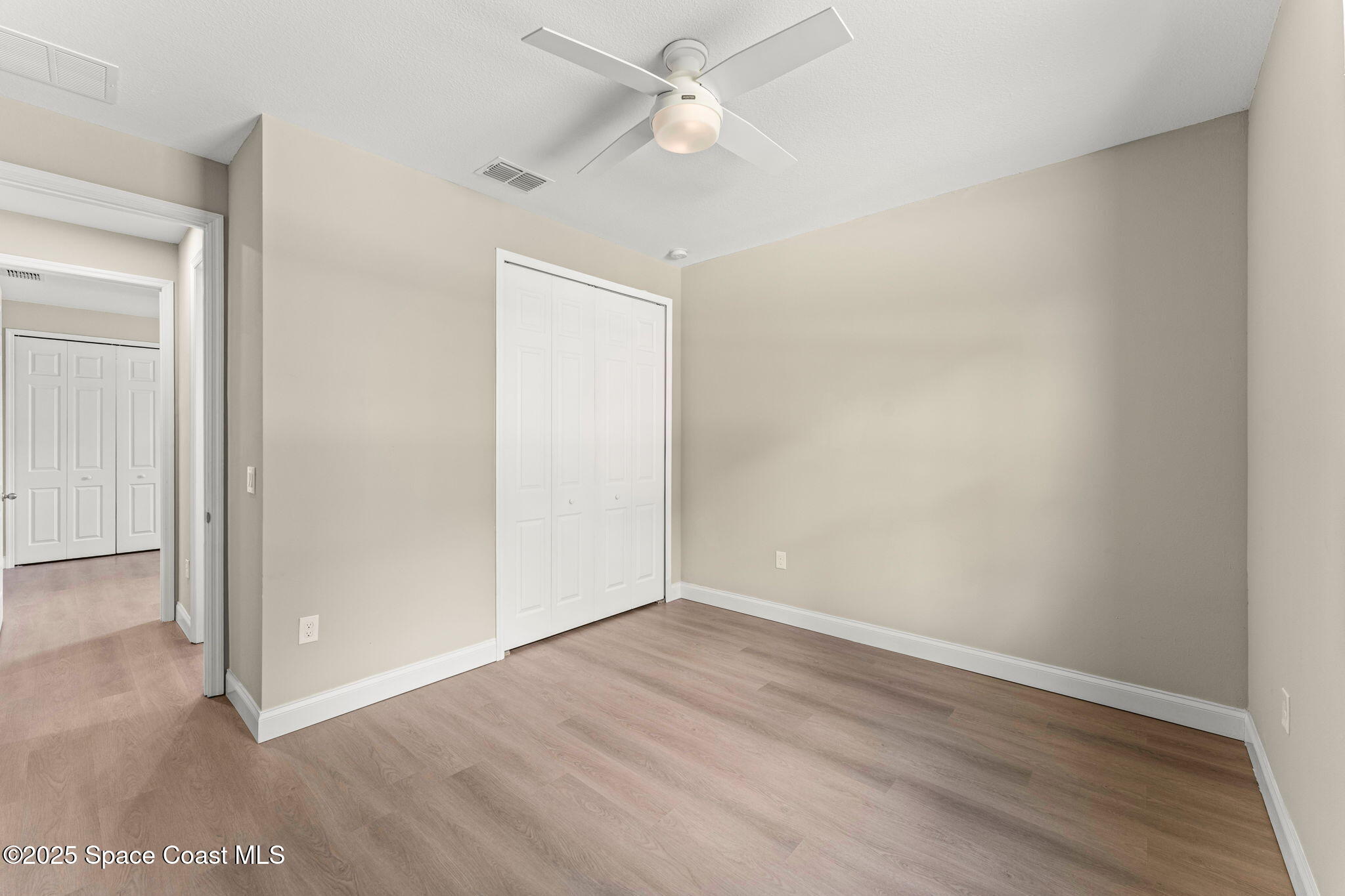 241 Sarah Road Southwest Palm Bay, FL 32908 - Photo 39 of 54 an empty room with wooden floor and fan