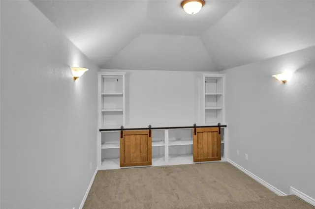 an empty room with windows and ceiling fan