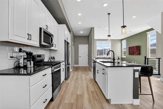 a kitchen with stainless steel appliances a sink stove and cabinets