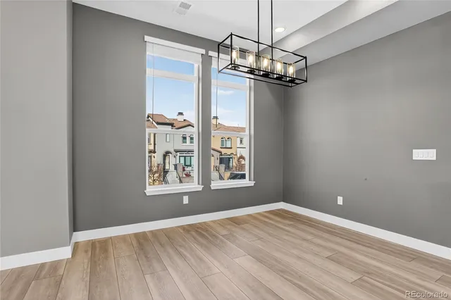 a view of a room with wooden floor chandelier and a window