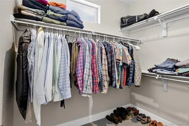 a view of walk in closet with clothes and shoes