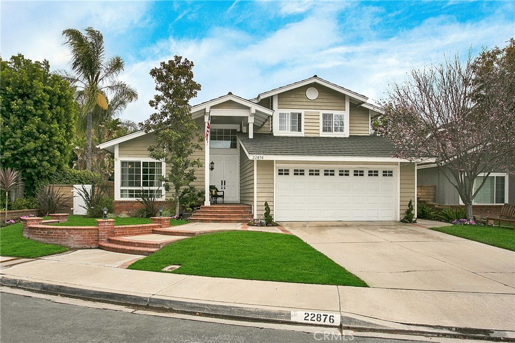 a view of a house with a yard and large tree