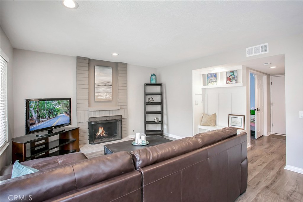 22876 Broadleaf Lake Forest, CA 92630 - Photo 11 of 26 a living room with furniture a flat screen tv and a fireplace
