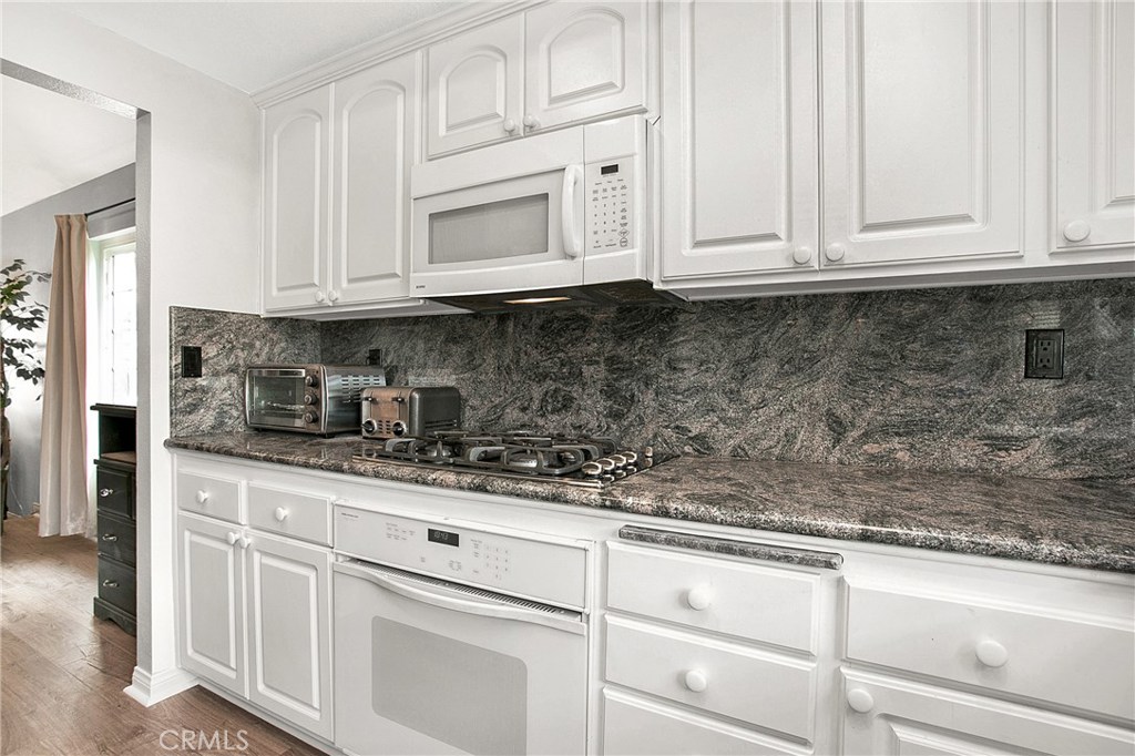22876 Broadleaf Lake Forest, CA 92630 - Photo 8 of 26 a kitchen with white cabinets and white appliances