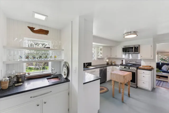 a kitchen with a sink and chairs