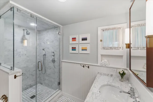 a bathroom with a tub a sink and glass door shower