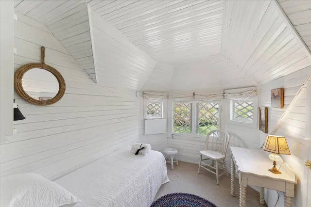 a bedroom with a bed a table and chair